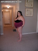 Plump horny wife with enormous boobs exposing her goods on the bed.